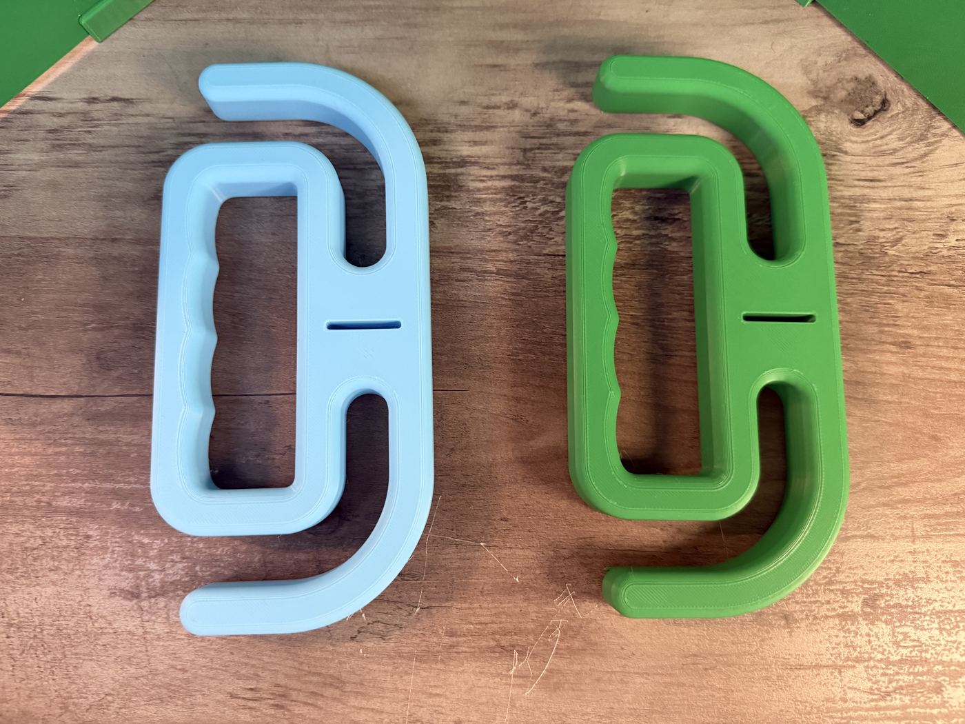 Two double-ended wall or shelf hooks in blue and green