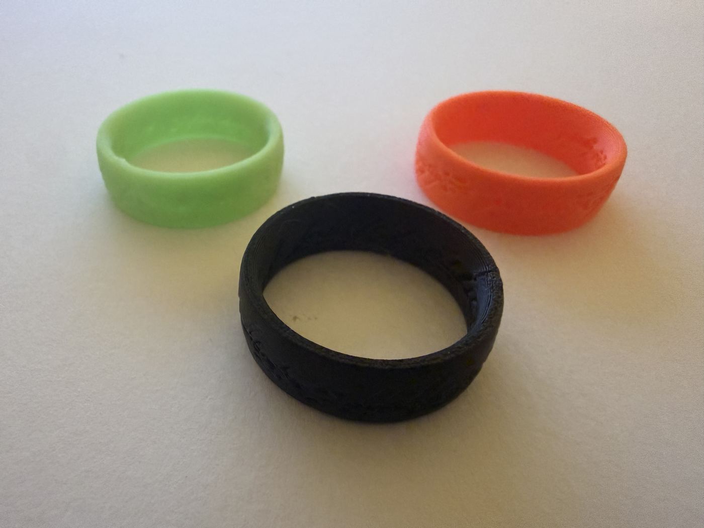 Set of three stackable printed rings in green, orange, and black